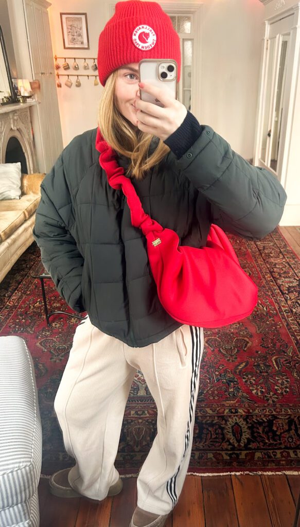 Warm casual winter outfit with a halfdays puffer jacket, knit sweater, adidas track pants, boots, and a beanie for running errands