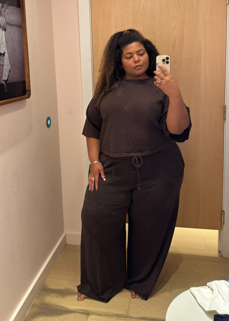 Plus-size woman in a dressing room wearing Aerie's cotton matching set in chocolate brown.