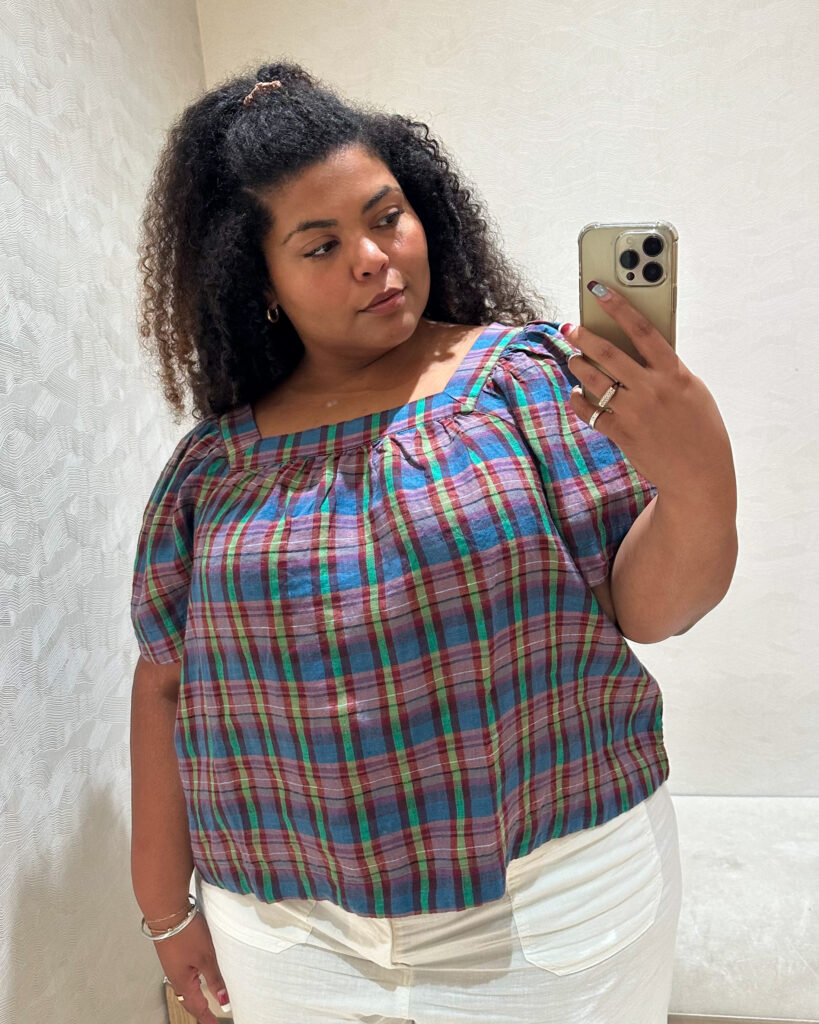 Plus-size woman trying on Banana Republic's Linen Square-Neck Top in blue plaid over white pants.